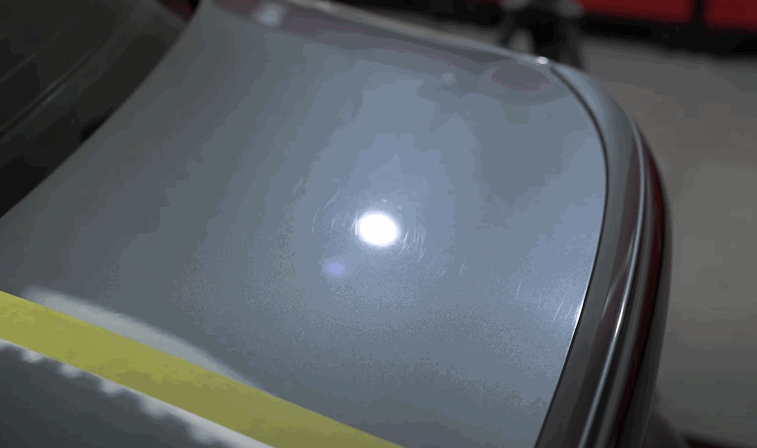 A spotlight reveals swirl marks and micro-scratches on a dull paint surface, indicating the need for paint correction before ceramic coating.