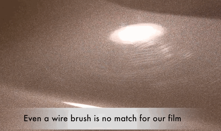 Demonstration of a wire brush being used over a coated paint surface, with no visible damage to the finish.